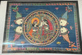 The Mithila or Madhubani style artwork painting from Saanskrityam Handicraft Store beautifully showcases two figures in lively traditional attire, facing each other. One figure is depicted with a yellow face and the other with a blue one, both embellished with intricate patterns and floral motifs. They stand beneath a tree featuring red and green leaves, encapsulating the essence of this folk art style.