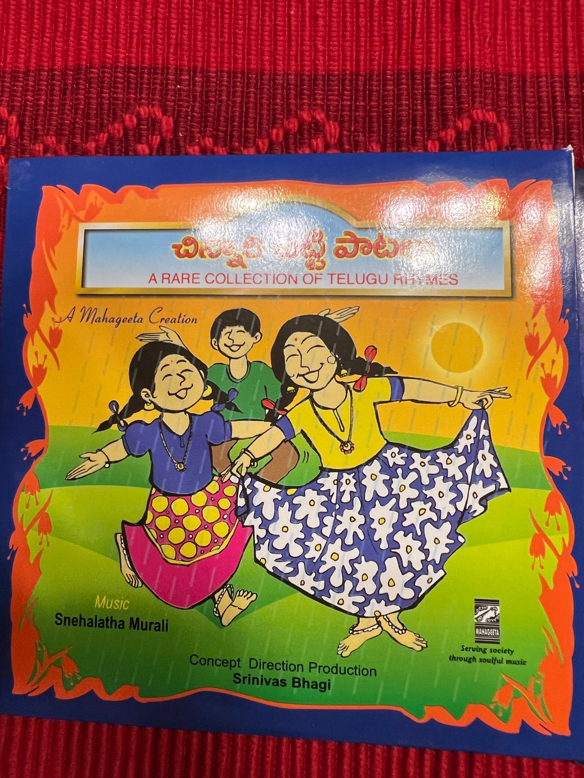 Three packages of the Indian Music Collection incense sticks from Saanskrityam Handicraft Store are arranged on a red fabric. The purple boxes with gold text, featuring an OM symbol and various logos, evoke rich fragrances akin to the soothing notes of Carnatic music.