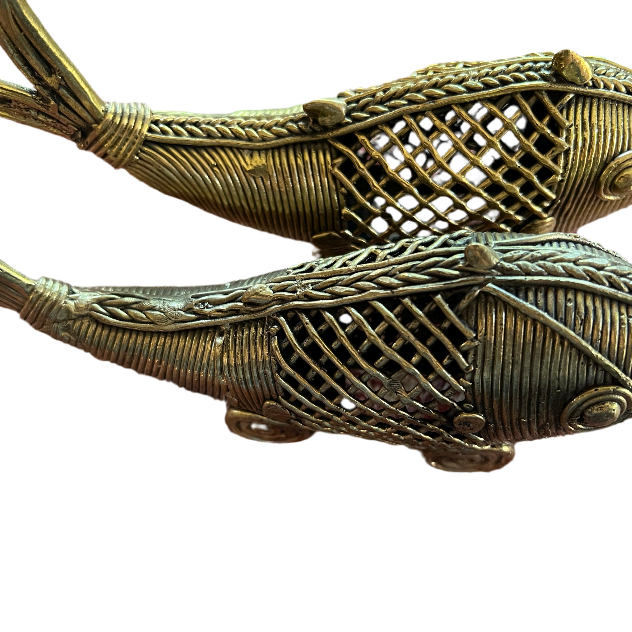 Two intricately designed bronze fish sculptures from Saanskrityam Handicraft Store's Odisha/Orissa collection, crafted in the traditional Dhokra art style of Odisha, showcase detailed weaving patterns and expressive features, positioned side by side.