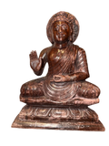 A serene Buddha statue from the Saanskrityam Handicraft Store's Buddha Dharma collection elegantly holds a bowl in its lap. Featuring intricate hair curls, elongated ears, and a flame-like ornament atop its head, this piece enhances any Buddha collection. It stands gracefully on a round, decorated base.