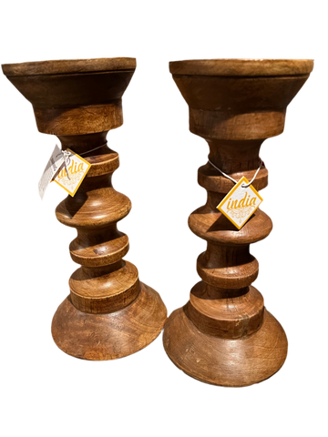 These Holiday Gifts from Saanskrityam Handicraft Store, crafted as wooden candle holders with stacked, rounded sections and tags marked "India," make perfect presents for the holiday season. Arranged on a dark background, they bring a touch of elegance and joy to any celebration.