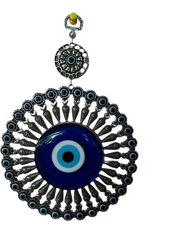 The "Türkiye Treasures" pendant from Saanskrityam Handicraft Store showcases a large decorative blue eye, also referred to as an evil eye warder. It is adorned with intricate metal detailing and smaller blue eye motifs encircling a circular frame, inspired by traditional Turkish designs. The pendant features an ornate hanger at the top for added elegance.