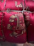 A close-up of the Jaipuri Razai, a cozy queen-size satin comforter by Saanskrityam Handicraft Store, featuring gold elephant designs on a purple background. This exquisite fabric, handmade in Rajasthan, is quilted and secured with white ties.