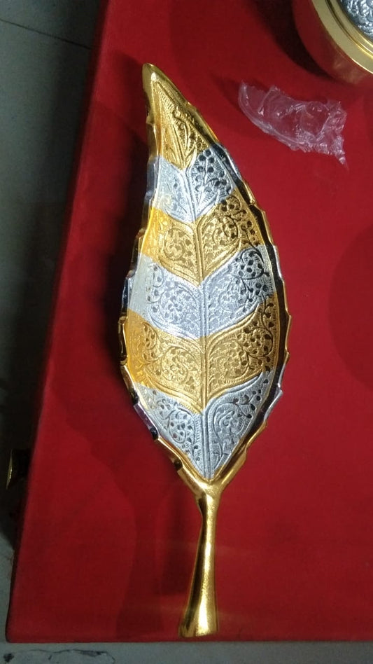 This Saanskrityam Handicraft Store collection offers a luxurious velvet gift box, perfect as a wedding, festival, or corporate gift. It contains two ornately designed gold-plated bowls with matching spoons, beautifully displayed in a red velvet setting. The box is finished with an elegant gold latch and includes a tray that features intricate detailing throughout.