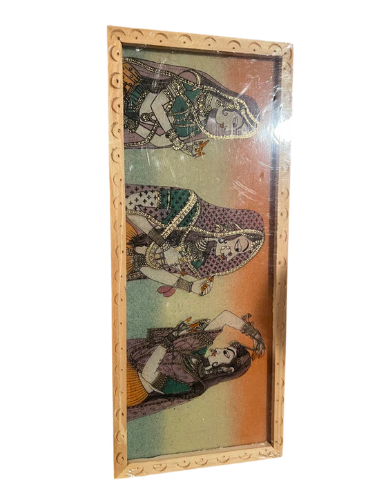 A Jewel box or trinket box featuring a depiction of three women in traditional attire with intricate jewelry and embellishments, set against a gradient background. The wooden product from Saanskrityam Handicraft Store is ornately designed.