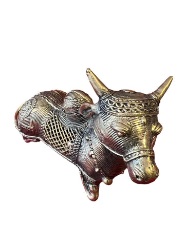 Introducing the Nandi or Shiva’s Bull, an exquisite sculpture from Saanskrityam Handicraft Store. This detailed metal masterpiece features intricate patterns and embellishments, with ornate designs meticulously crafted on both its body and head, all fashioned from a lustrous metallic material.