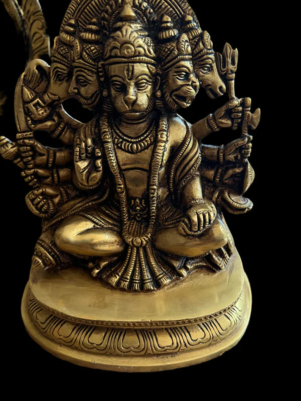 Product Name: Panchamukha Hanuman 6 inch bronze  
Brand Name: Saanskrityam Handicraft Store

Description: The Panchamukha Hanuman bronze statue by Saanskrityam Handicraft Store showcases a multi-headed deity seated in a cross-legged position. It features intricate carvings and holds various symbolic objects in multiple hands, with its detailed craftsmanship highlighted against a dark background.