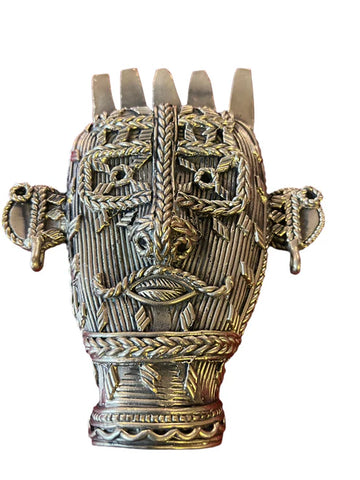 Introducing the Tribal face mask from Saanskrityam Handicraft Store, a stunning decorative metal sculpture of a face featuring intricate patterns. This piece showcases elongated ears embellished with rings, braided hair details, and facial decorations. The symmetrical design emphasizes texture and exceptional craftsmanship.